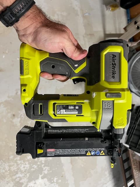 Front photo of a Ryobi brad nailer held in a garage